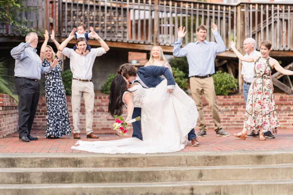 Newlyweds posing on stairs at American Tobacco Campus, a popular Durham wedding photography location featuring an industrial backdrop.