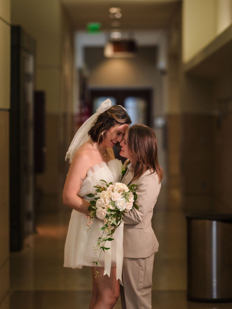 newly married lesbian couple in their fancy outfit in durham courthouse during their wedding